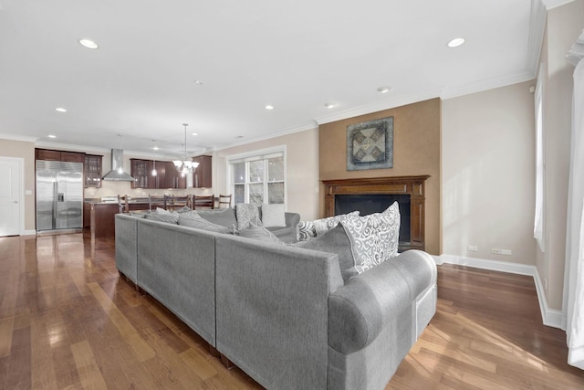 living room with baseboards, dark wood-type flooring, crown molding, and recessed lighting