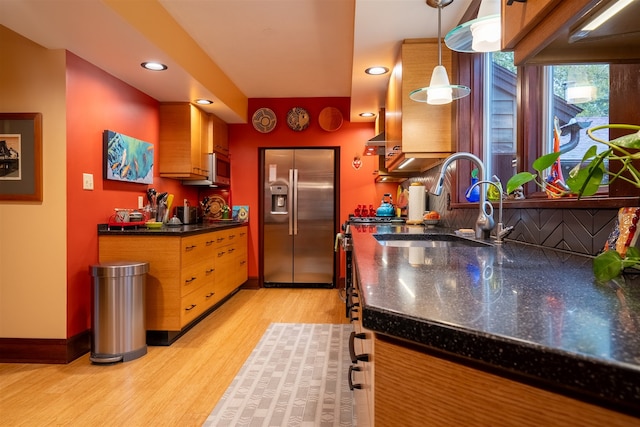 kitchen featuring decorative backsplash, light hardwood / wood-style flooring, sink, appliances with stainless steel finishes, and decorative light fixtures