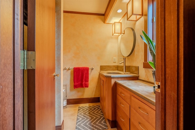 bathroom with ornamental molding and vanity