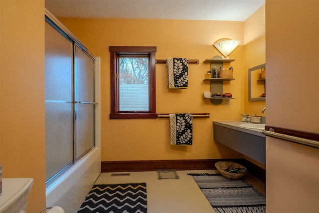 bathroom featuring vanity and bath / shower combo with glass door