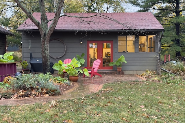 back of property featuring a lawn and french doors