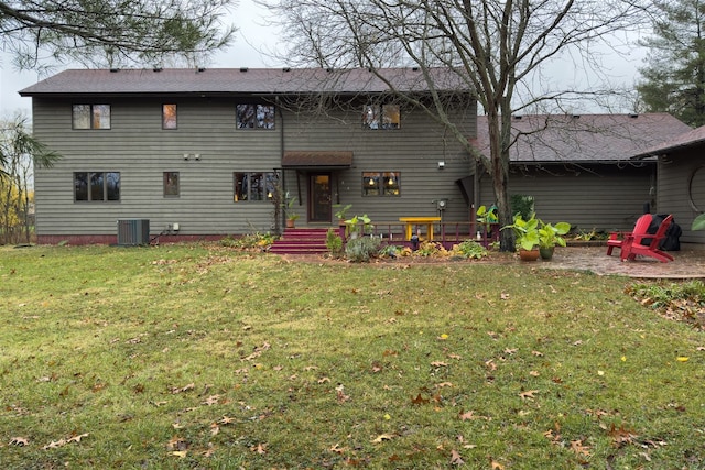 rear view of house featuring central AC unit, a lawn, and a patio area