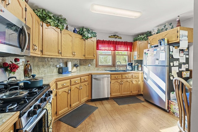 2708 Lake Shore Dr Unit 1, Joliet, IL 60431 - kitchen with appliances with stainless steel finishes, a sink, light wood finished floors, tasteful backsplash, and tile counters