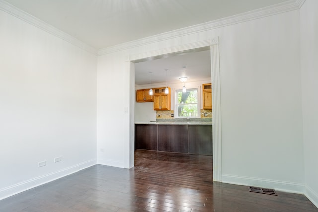 unfurnished living room featuring dark wood-type flooring, sink, and crown molding