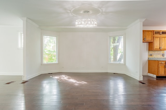 unfurnished dining area featuring ornamental molding, a notable chandelier, and dark hardwood / wood-style floors