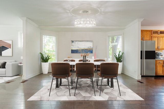 dining area with a notable chandelier, dark hardwood / wood-style floors, and crown molding