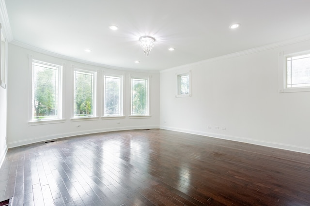 empty room with dark hardwood / wood-style floors, an inviting chandelier, and ornamental molding