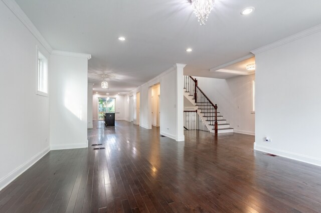 spare room with dark wood-type flooring, a notable chandelier, and crown molding