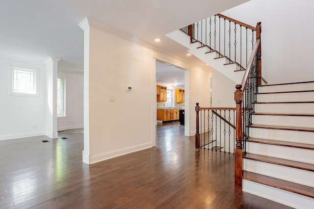 stairway featuring ornamental molding and wood-type flooring