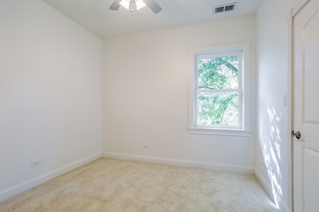 empty room featuring light colored carpet and ceiling fan