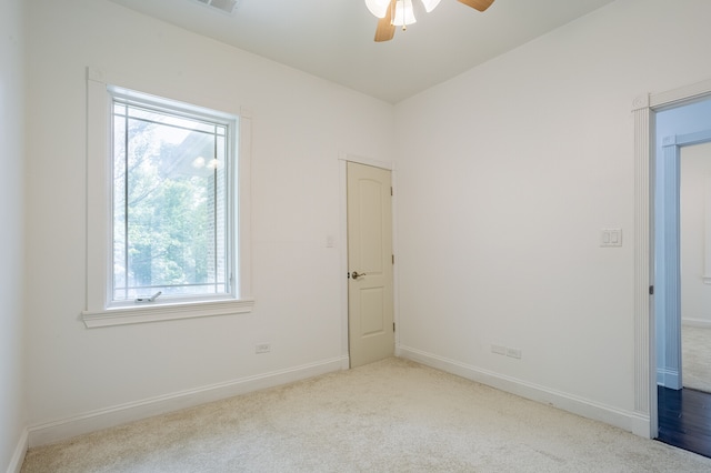 carpeted spare room featuring ceiling fan