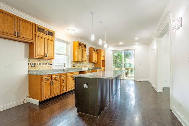 kitchen featuring dark hardwood / wood-style flooring, hanging light fixtures, a healthy amount of sunlight, and a center island