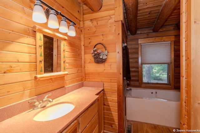 bathroom with hardwood / wood-style flooring, wooden ceiling, vanity, beam ceiling, and a bath