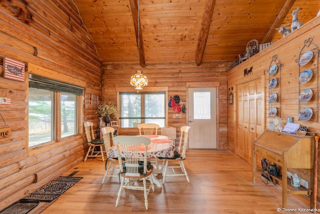 dining area featuring a healthy amount of sunlight, light wood-type flooring, and vaulted ceiling with beams