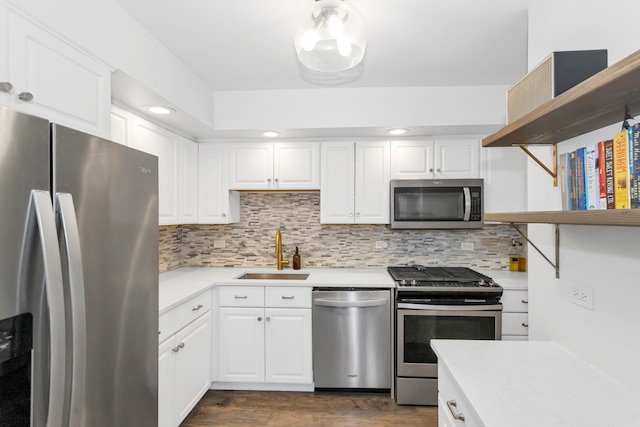 kitchen with stainless steel appliances, white cabinetry, sink, tasteful backsplash, and dark wood-type flooring