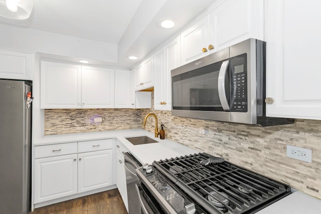 kitchen with decorative backsplash, sink, dark hardwood / wood-style floors, white cabinetry, and appliances with stainless steel finishes