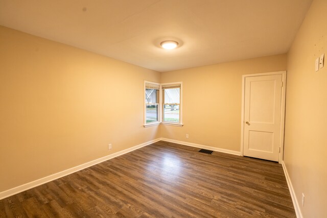 unfurnished room with dark hardwood / wood-style flooring