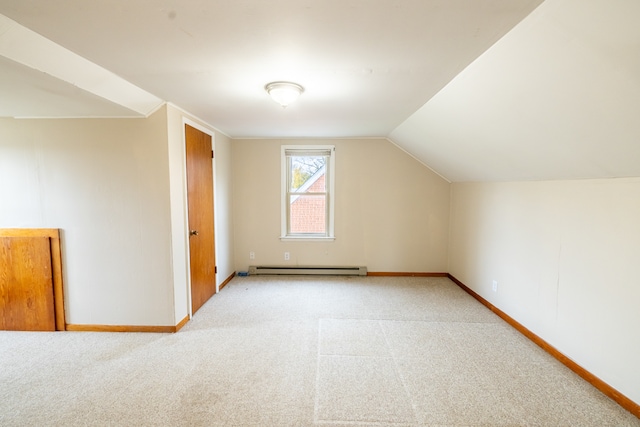 additional living space featuring baseboard heating, lofted ceiling, and light colored carpet