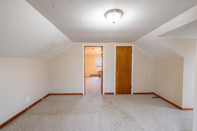 bonus room with lofted ceiling and light carpet