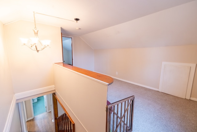 additional living space featuring carpet, a chandelier, and vaulted ceiling