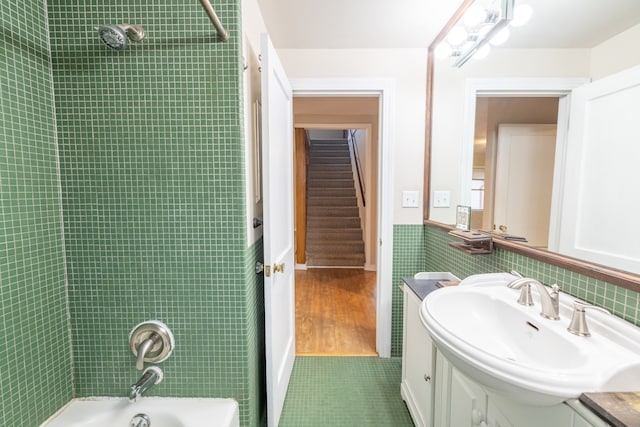 bathroom featuring vanity, tile patterned floors, tile walls, and tiled shower / bath combo