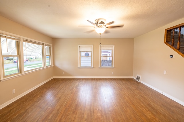 unfurnished room with wood-type flooring, a textured ceiling, and ceiling fan