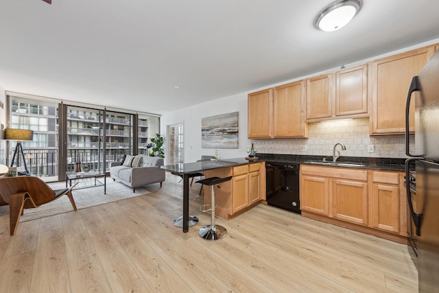 kitchen with plenty of natural light, light hardwood / wood-style flooring, and black dishwasher