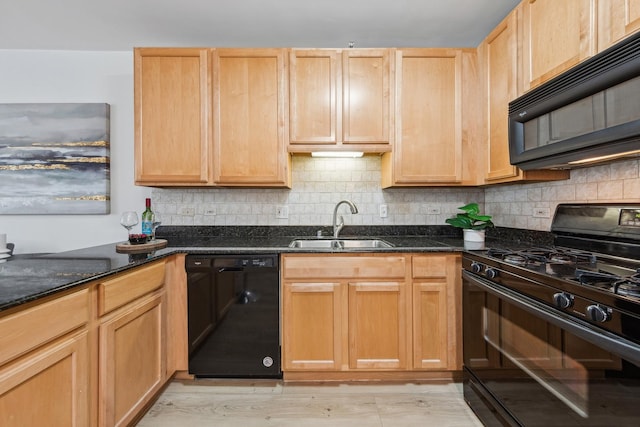 kitchen featuring sink, tasteful backsplash, light hardwood / wood-style flooring, dark stone countertops, and black appliances