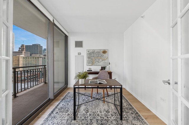 home office with wood-type flooring and french doors