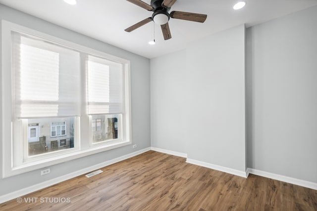 empty room with hardwood / wood-style floors and ceiling fan