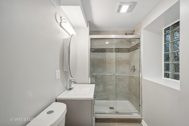 bathroom featuring walk in shower, vanity, and toilet