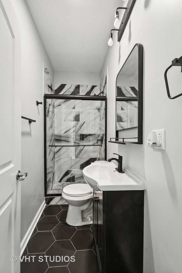 bathroom with toilet, vanity, tile patterned flooring, and a shower with door