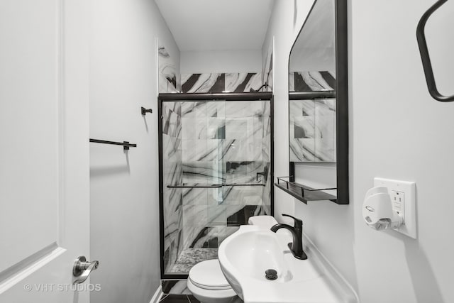 bathroom with walk in shower, sink, and toilet