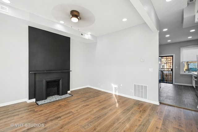 unfurnished living room featuring wood-type flooring and ceiling fan