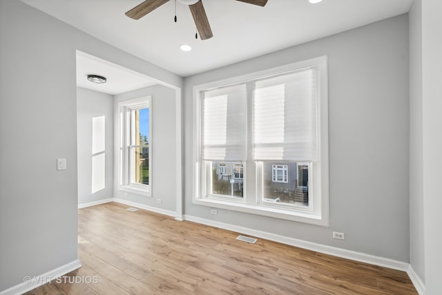 spare room with light wood-type flooring and ceiling fan