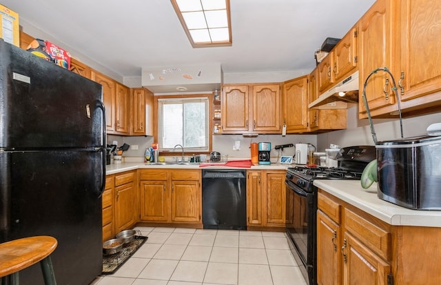 kitchen featuring black appliances, sink, and light tile patterned floors