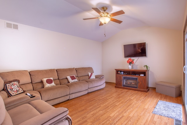 living room with light hardwood / wood-style flooring, lofted ceiling, and ceiling fan