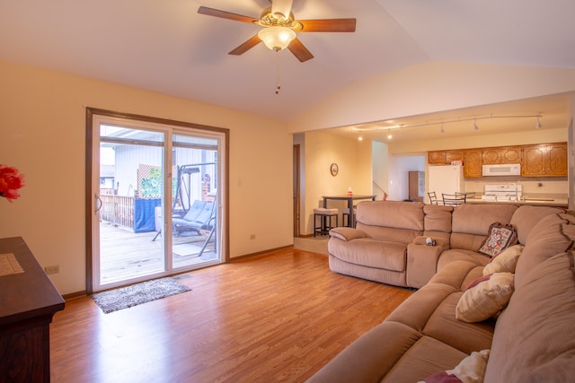 living room with light wood-type flooring, rail lighting, ceiling fan, and vaulted ceiling