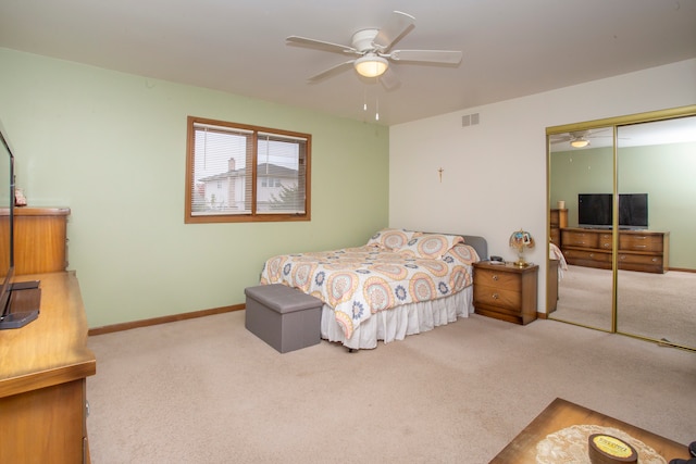 bedroom featuring light carpet, ceiling fan, and a closet