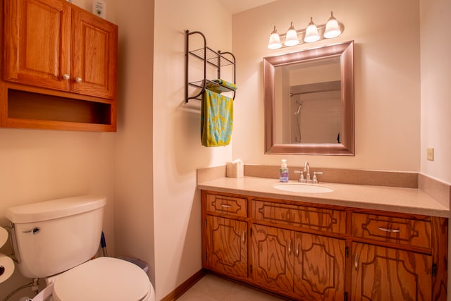 bathroom with toilet, vanity, and tile patterned floors