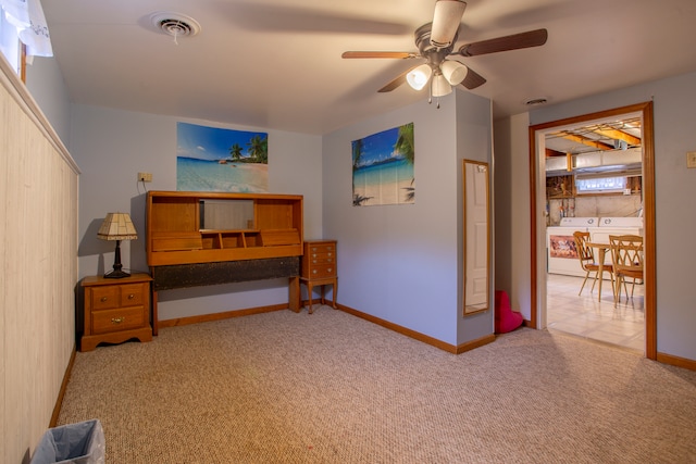 bedroom with washing machine and dryer, light carpet, and ceiling fan