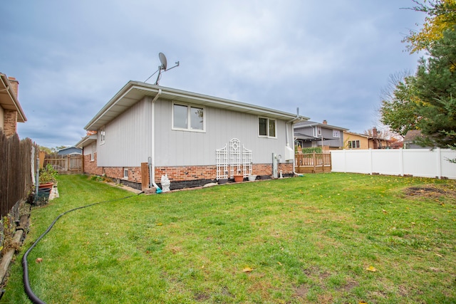 rear view of property featuring a lawn