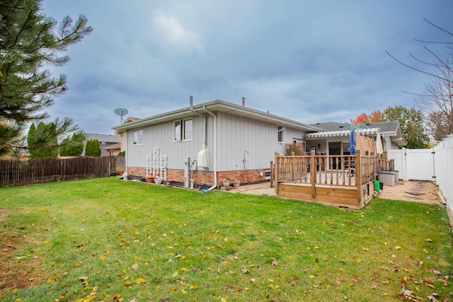 back of property featuring a wooden deck, a lawn, and a pergola