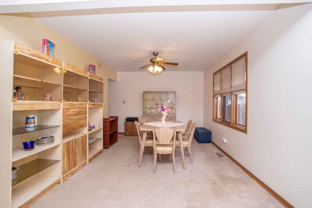 dining space with ceiling fan and carpet flooring