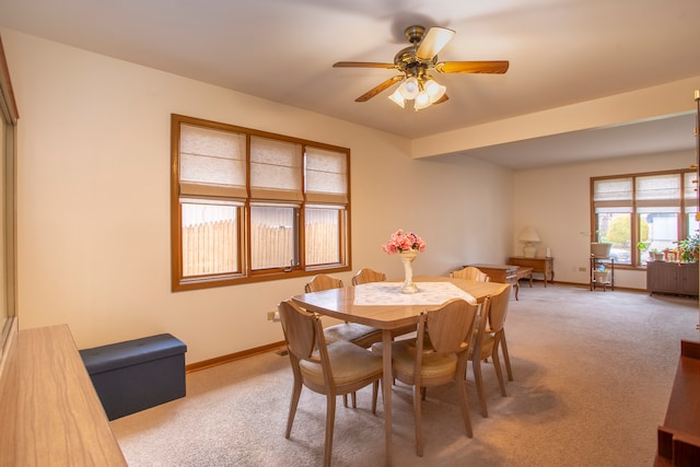 carpeted dining room with ceiling fan