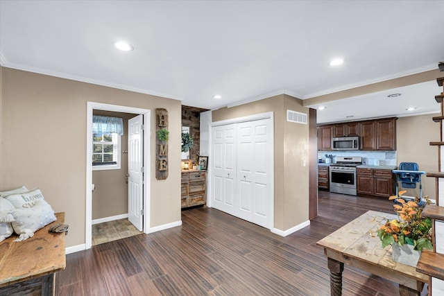 kitchen with ornamental molding, appliances with stainless steel finishes, dark brown cabinetry, and dark hardwood / wood-style flooring