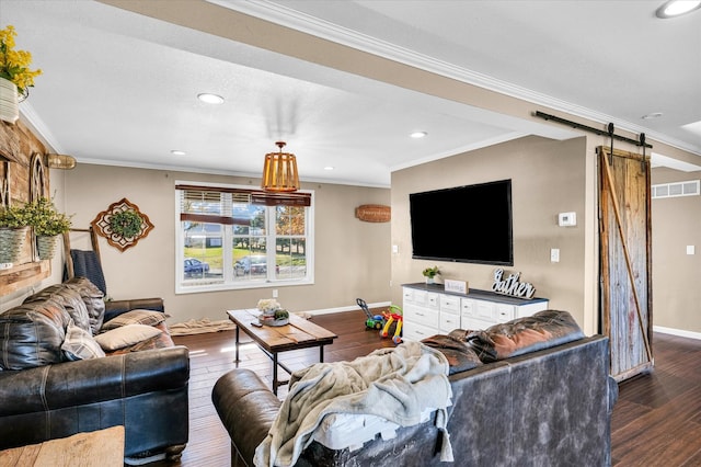 living room featuring a barn door, dark wood-type flooring, and ornamental molding