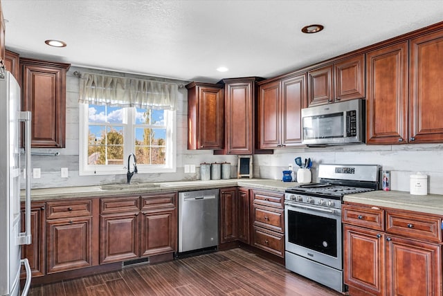 kitchen featuring stainless steel appliances, sink, tasteful backsplash, a textured ceiling, and dark hardwood / wood-style flooring