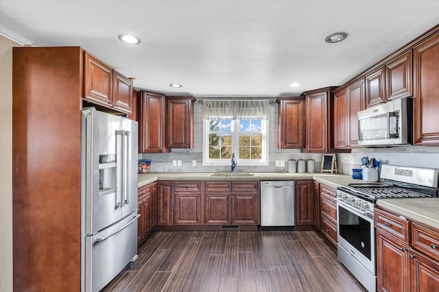 kitchen with tasteful backsplash, stainless steel appliances, a textured ceiling, dark hardwood / wood-style flooring, and sink