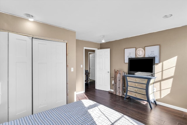 bedroom with dark wood-type flooring and a closet